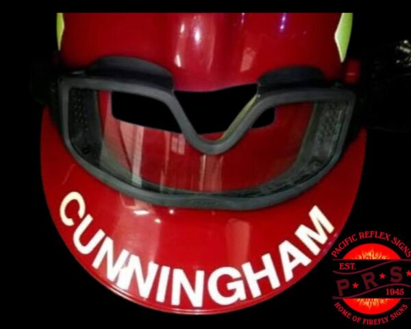 A red baseball helmet with the name cunningham written on it.